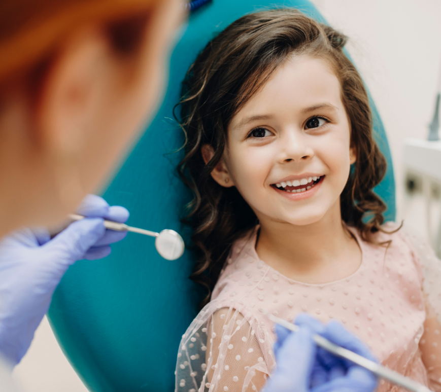 Young woman in dental chair with fluoride trays on her teeth